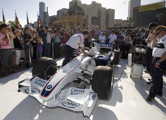 Spectators watch a BMW being started as preparations gather pace for the opening grand prix in Melbourne