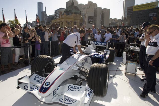 Spectators watch a BMW being started as preparations gather pace for the opening grand prix in Melbourne