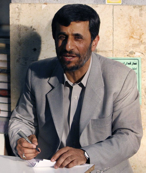 Iranian President Mahmoud Ahmadinejad fills in his ballot for the parliamentary elections