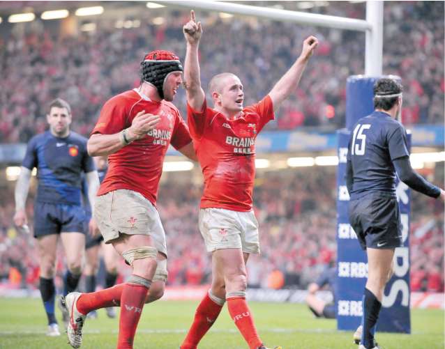 Welsh superstar Shane Williams salutes the Millennium Stadium crowd after scoring the first try which set the Red Dragons on their way to Grand Slam glory
