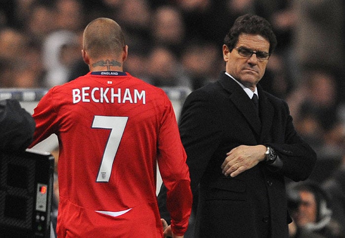 Fabio Capello watches as David Beckham leaves the field after being substituted in the 62nd minute of his 100th international appearance in Paris last night