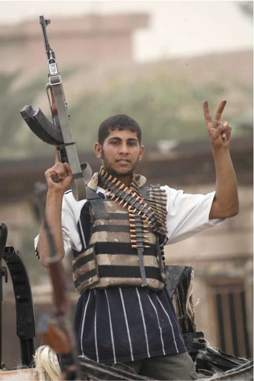A Mehdi Army fighter flashes a victory sign in Basra yesterday