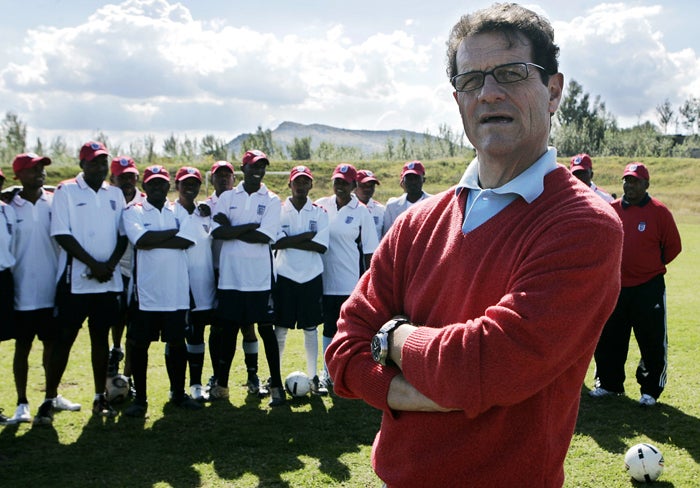 Fabio Capello is joined by youngsters wearing England shirts during a goodwill visit to the Lesotho Football Association headquarters in Maseru yesterday