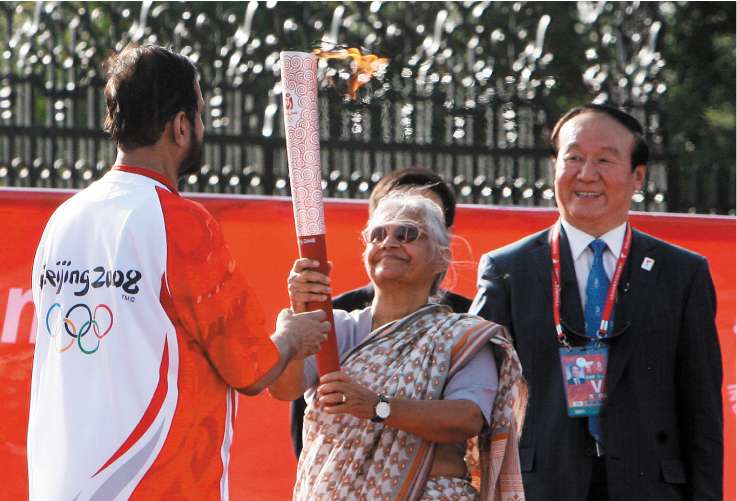 Chief Minister of Delhi State Sheila Dikshit (centre) receives the torch from Indian Olympics Association President Suresh Kalmadi