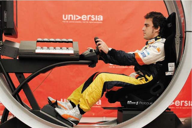 Fernando Alonso tries out a video game as Formula One prepares for the Spanish Grand Prix this weekend