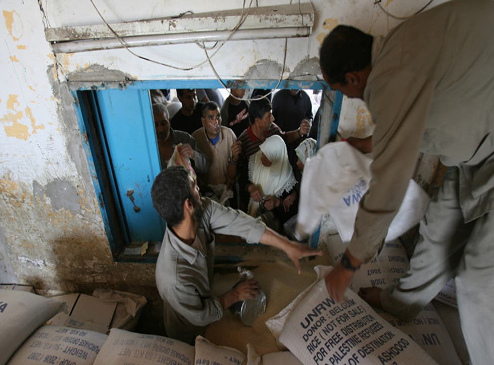 The UN Relief and Works Agency distributes food aid to refugees in the al-Shati refugee camp in Gaza yesterday before the deliveries were suspended