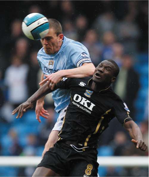 Manchester City captain Richard Dunne out jumps Portsmouth's Papa Bouba Diop
