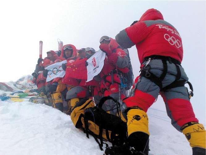 Chinese climbers celebrate with the Olympic torches as they reach the summit of Mount Everest