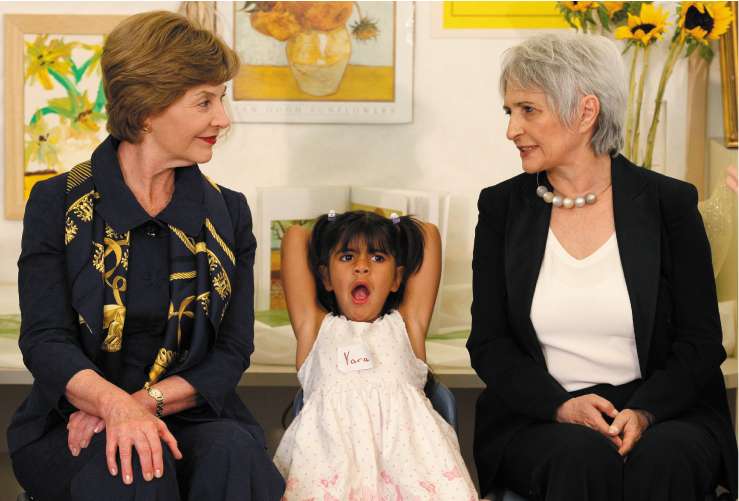A child yawns as Laura Bush chats to Aliza Olmert, the Israeli Prime Minister's wife, at a school in Jerusalem