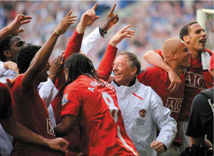 Sir Alex Ferguson celebrates with his players after Manchester United's title triumph at Wigan