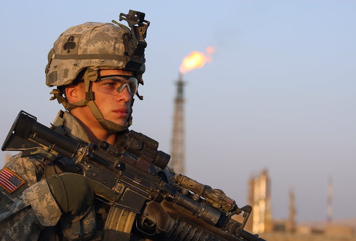 A US soldier stands guard in front of an Iraqi oil refinery near Baiji