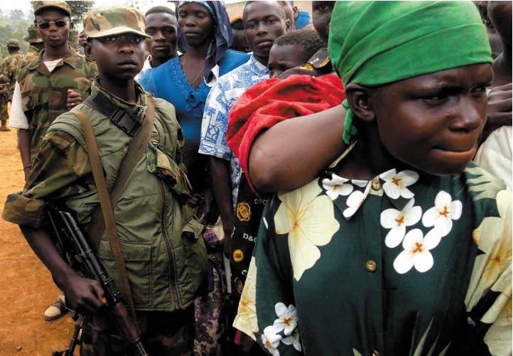 A child soldier patrols in Ituri province during a rally held by UPC leader Thomas Lubanga