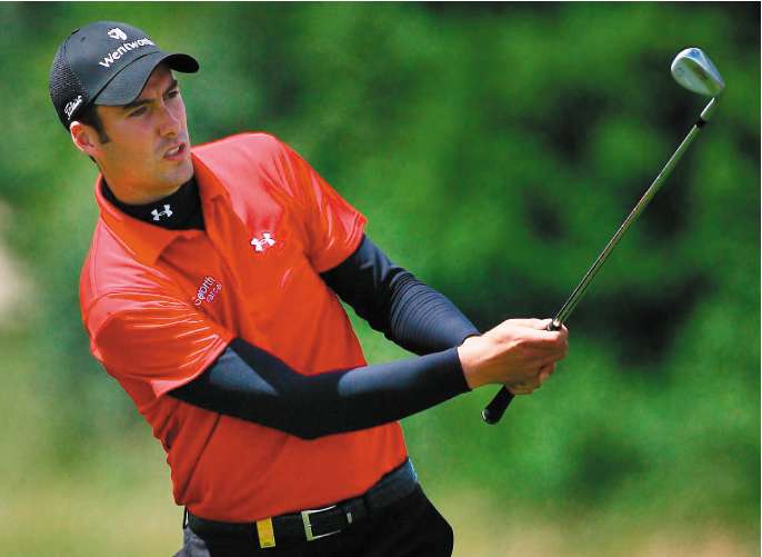 Ross Fisher plays his approach to the ninth hole after his 413-yard drive on the way to leading the European Open yesterday