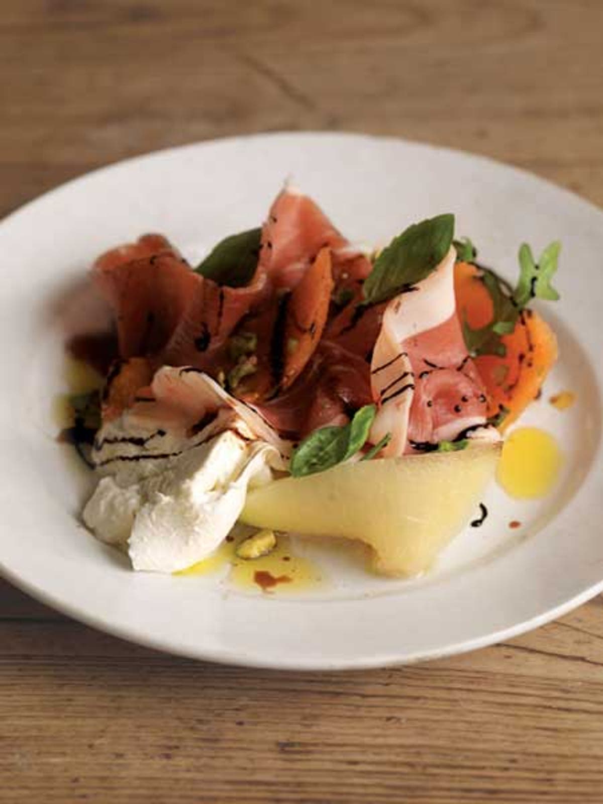 Mozzarella salad with prosciutto di Parma, melon and pistachios The
