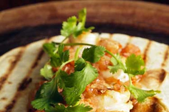 Warm the tortillas, lay on the prawns and top with the salsa and sprigs of coriander