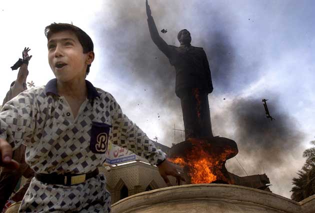 A statue of the ousted Saddam Hussein is set ablaze in Baghdad (Getty)