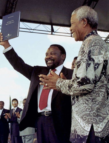Cyril Ramaphosa holds the newly signed South African constitution in 1996 as Nelson Mandela looks on