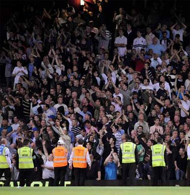 Stewards stand in front of the Millwall fans during the Carling Cup second round match at Upton Park