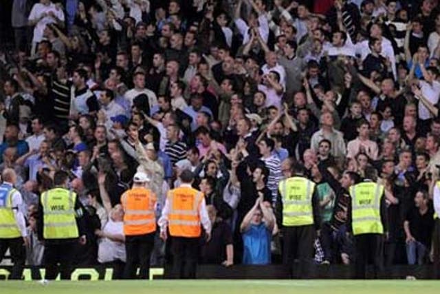 Stewards stand in front of the Millwall fans during the Carling Cup second round match at Upton Park
