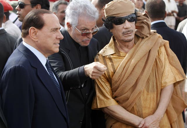 Then Italian prime minister Silvio Berlusconi and Muammar Gaddafi attend a ceremony to lay the first stone of a new Italian-funded highway, in Tuweisha, Libya, in 2009