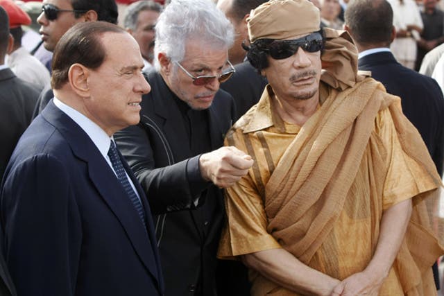 Then Italian prime minister Silvio Berlusconi and Muammar Gaddafi attend a ceremony to lay the first stone of a new Italian-funded highway, in Tuweisha, Libya, in 2009