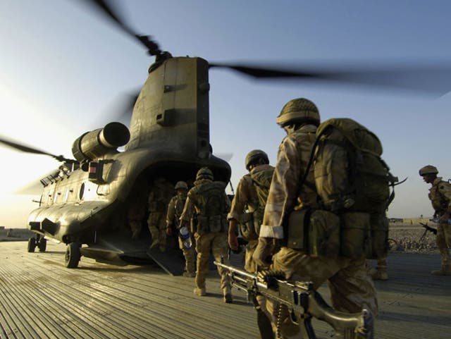 Paras and soldiers of the Royal Irish Regiment board an RAF Chinook in Camp Bastion