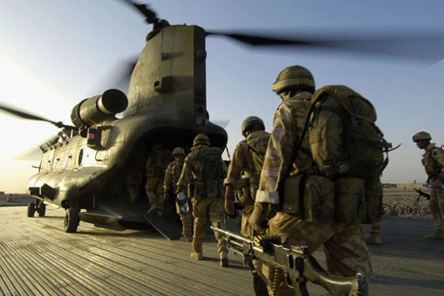 Paras and soldiers of the Royal Irish Regiment board an RAF Chinook in Camp Bastion