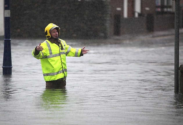 A firefighter directs colleagues as the River Gare floods Keswick in the Lake District