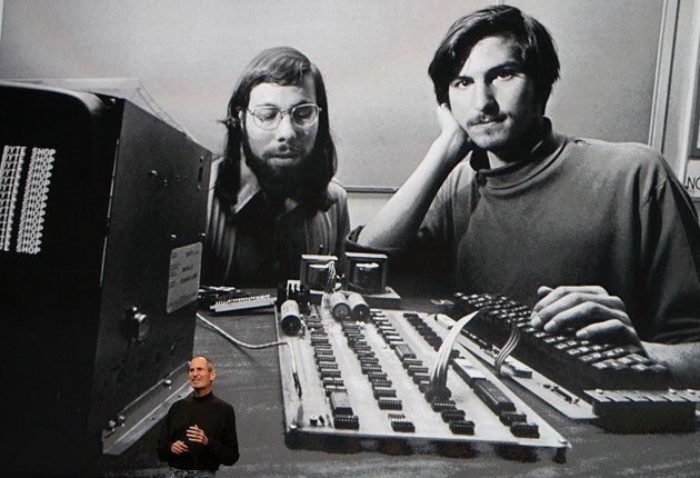Steve Jobs in front of a giant picture of a young Jobs, right, with his fellow Apple founder, Stephen Wozniak