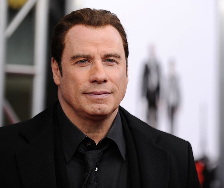 Charges against two people accused of trying to extort money from John Travolta were dropped today