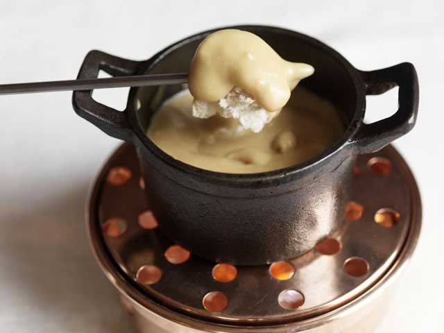 Serve the fondue on a table heater with the chunks of bread separately using long forks or skewers