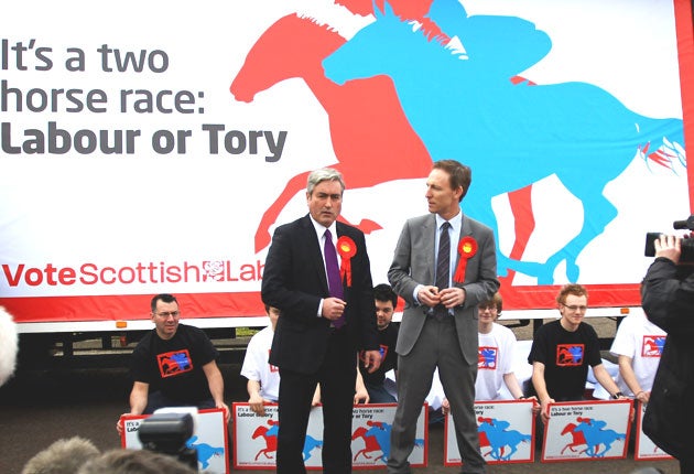 Jim Murphy, right, in front of a Labour poster from the 2010 election campaign
