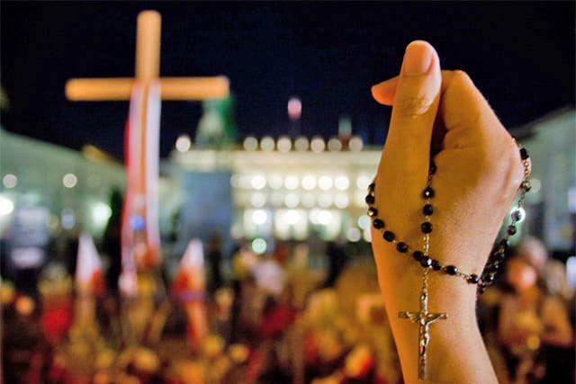 A woman holds a rosary during a rally