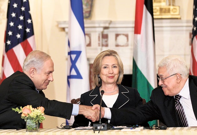 Benjamin Netanyahu shakes hands with Mahmoud Abbas while US Secretary of State Hillary Clinton beams approvingly
