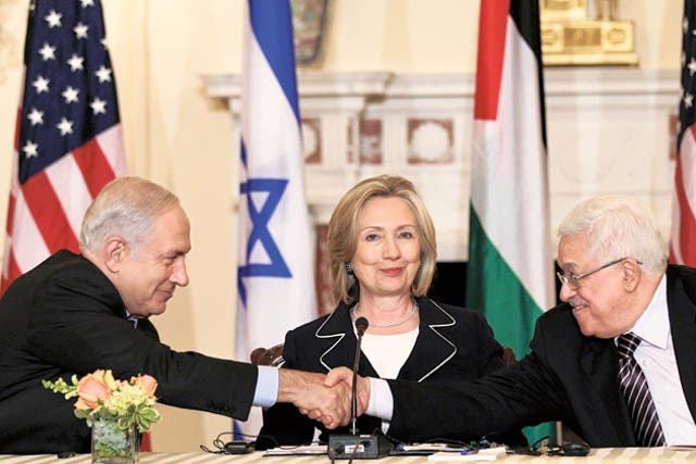 Benjamin Netanyahu shakes hands with Mahmoud Abbas while US Secretary of State Hillary Clinton beams approvingly