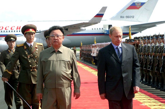 Russian President Vladimir Putin walks with North Korean leader Kim Jong-il past the guard of honour after arriving at the airport in the capital Pyongyang July 2000