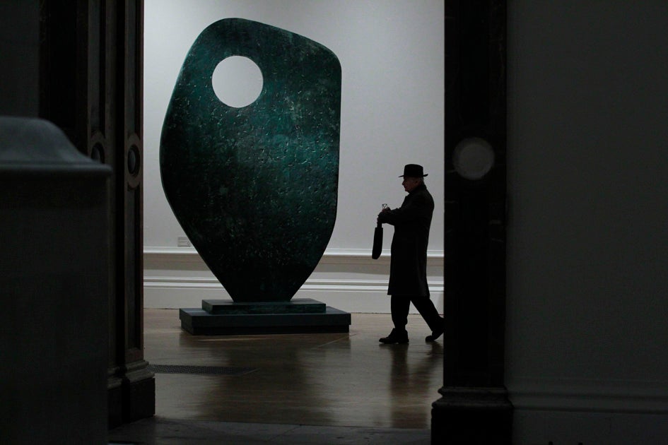 A man walks past the Barbara Hepworth sculpture "Single Form" during the press view for the Modern British Sculpture exhibition at the Royal Academy of Arts in London.