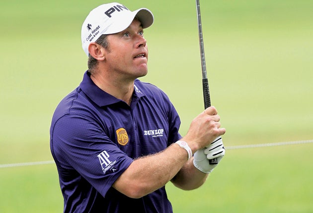 Lee Westwood keeps a close eye on his second shot from the rough on the 10th hole