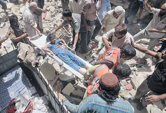 Rescue workers recover an injured girl from the rubble of a five-story residential building