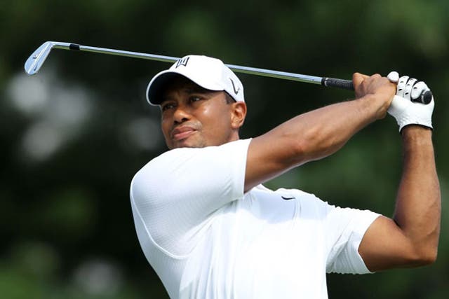 Tiger Woods hits his tee shot at the 17th on the way to one of his four
birdies in a one-over 71 at Firestone yesterday