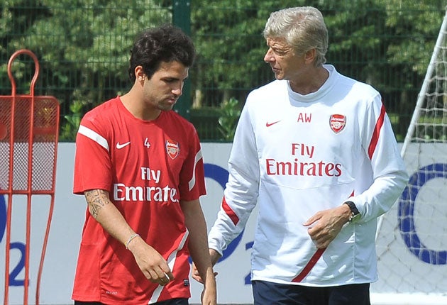 Cesc Fabregas (left), with Arsène Wenger, is not in Arsenal's squad to play Benfica