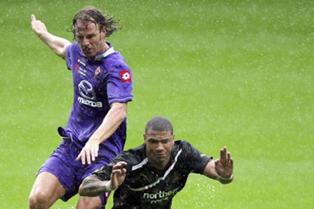 Splashing time: Leon Best takes a plunge at St James' Park under a challenge from Fiorentina's Cesare Natali before the referee Mark Halsey decided to call a halt