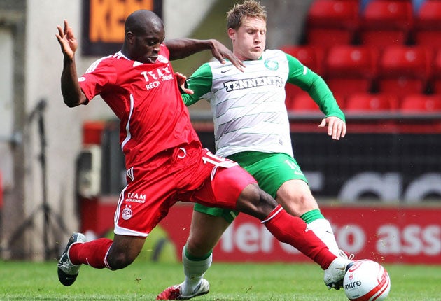 Celtic's Kris Commons and Aberdeen's Isaac Osbourne (left) battle for the ball at Pittodrie Stadium yesterday