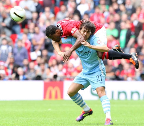 United's Patrice Evra and City's David Silva collide during the Community Shield