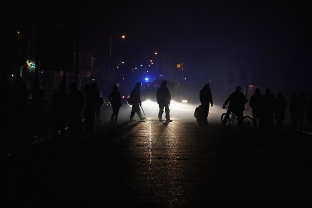 Police officers make their way down a blackened street after a blackout in Croydon, 8 August 2011