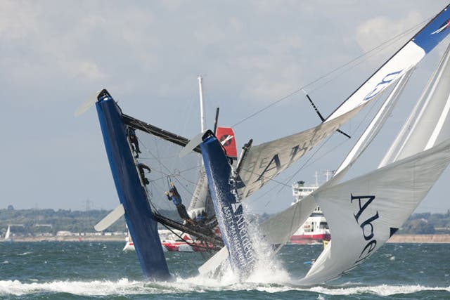 The crew hangs on as the 40-foot Aberdeen Asset Management catamaran cartwheels into a capsize at the Extreme Sailing Series in Cowes