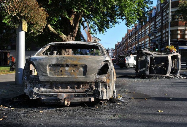 Burnt out cars are left in Ealing Green following a night of rioting