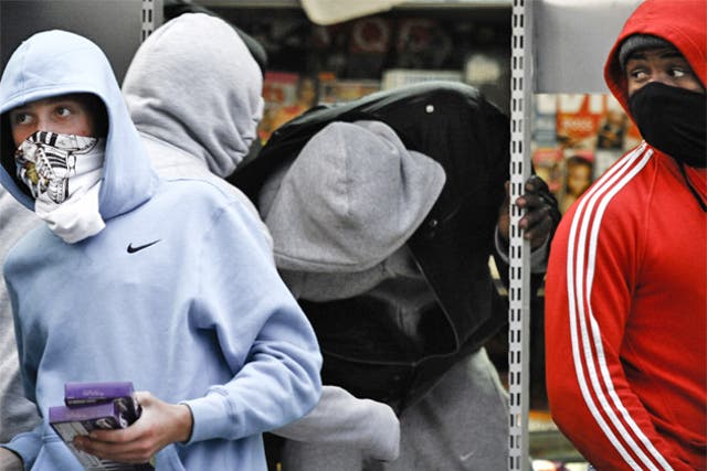 A gang of 'hoodies' loots a London grocery on Monday and hands out stolen goods