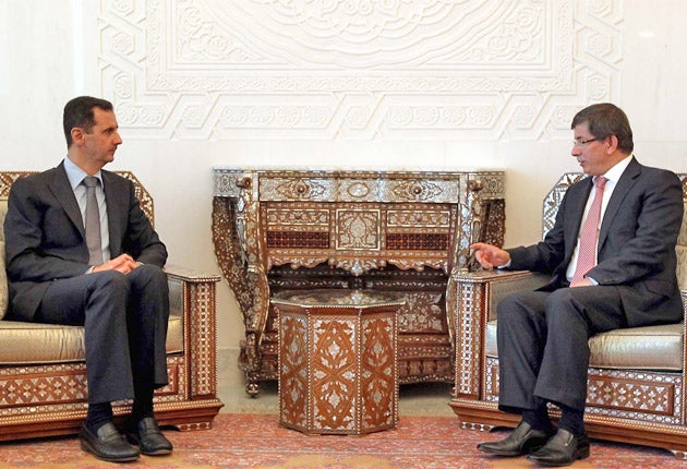 Syrian President Bashar al-Assad, left, meets Turkey's Foreign Minister Ahmet Davutoglu in Damascus yesterday