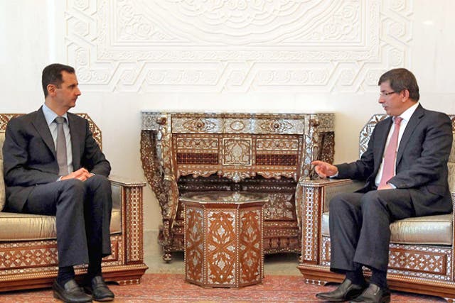 Syrian President Bashar al-Assad, left, meets Turkey's Foreign Minister Ahmet Davutoglu in Damascus yesterday